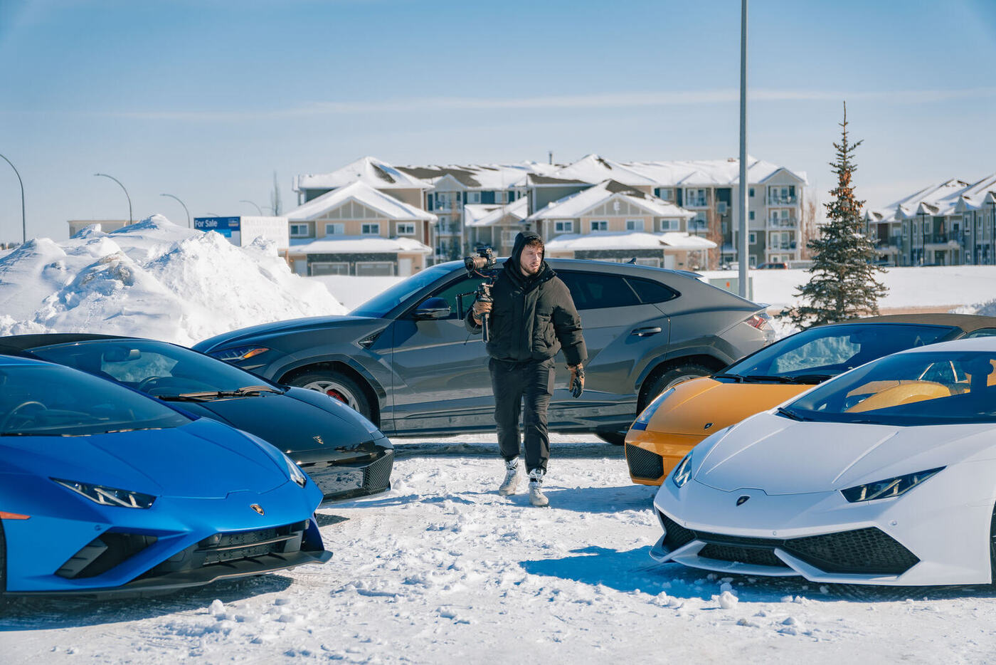 Videographer filming a lineup of Lamborghinis in the snow for an automotive brand