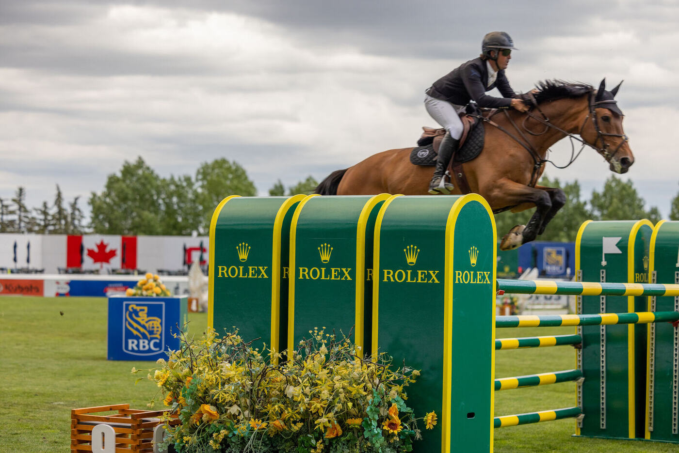 Show jumper clearing a Rolex fence at an equestrian event